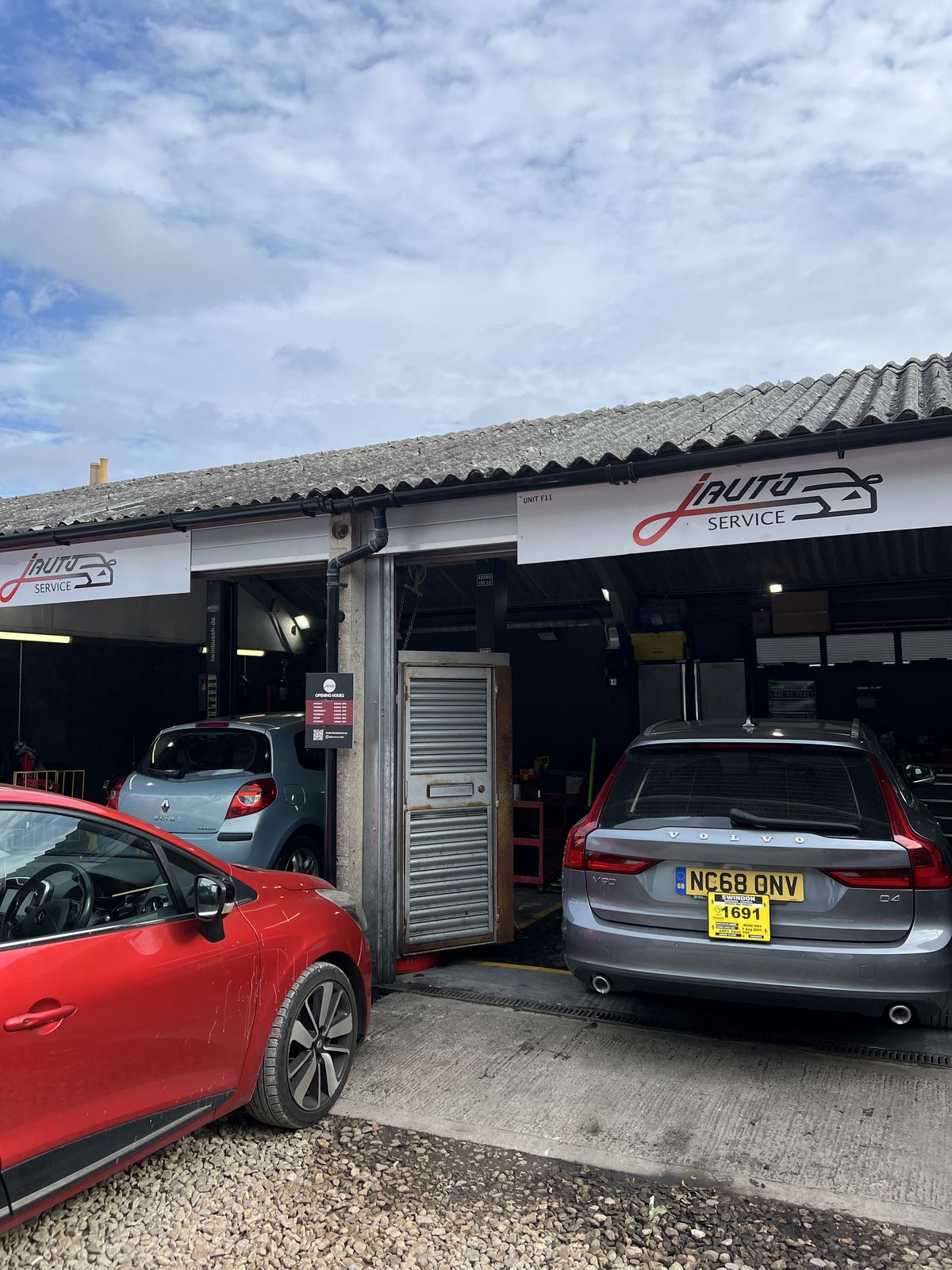 J Auto Service workshop entrance with signage and customer cars at Hibberds Yard, West Swindon